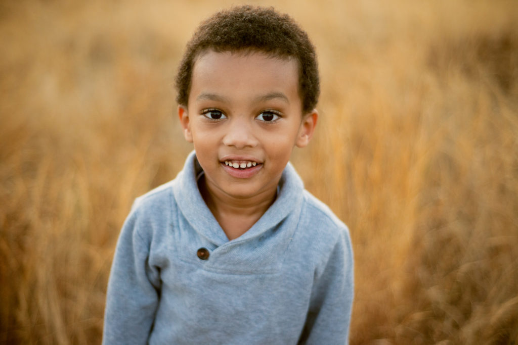 Picture of a sweet little boy in a grey sweatshirt that I photographed because of Buy Nothing